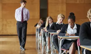 Uczniowie piszą maturę. Nauczyciel czuwa. Dysleksja na maturze to wyzwanie, ale determinacja pomaga pokonać trudności.