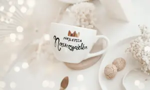 Biały kubek z napisem "Najlepsza Nauczycielka" i koroną. Idealny pomysł, co kupić wychowawcy na koniec roku.