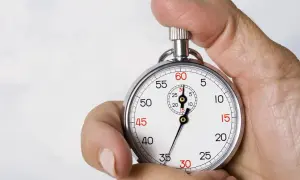 Dłoń trzyma stoper, odmierzając czas. Czy to już koniec lekcji, ile trwa matematyka podstawowa?