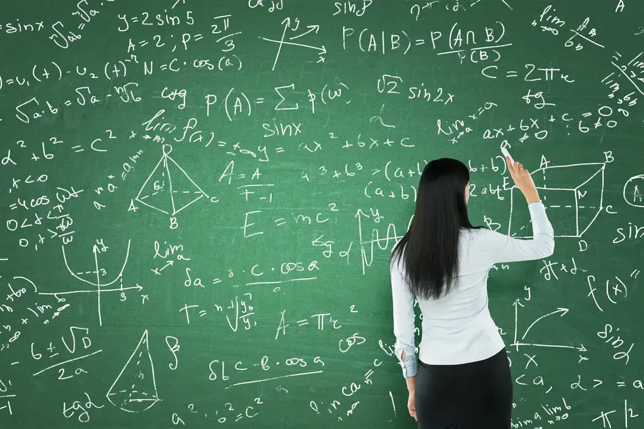 Nauczycielka pisze na tablicy wzory matematyczne, przygotowując się do tego, jak zdać maturę z matematyki.