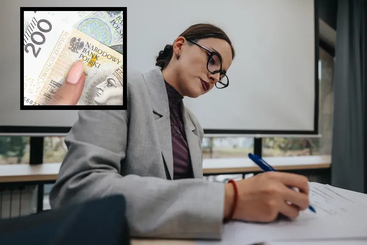 Kobieta w okularach pisze, a obok widać banknot 200 zł. Czy to symbol niskich zarobków w oświacie?