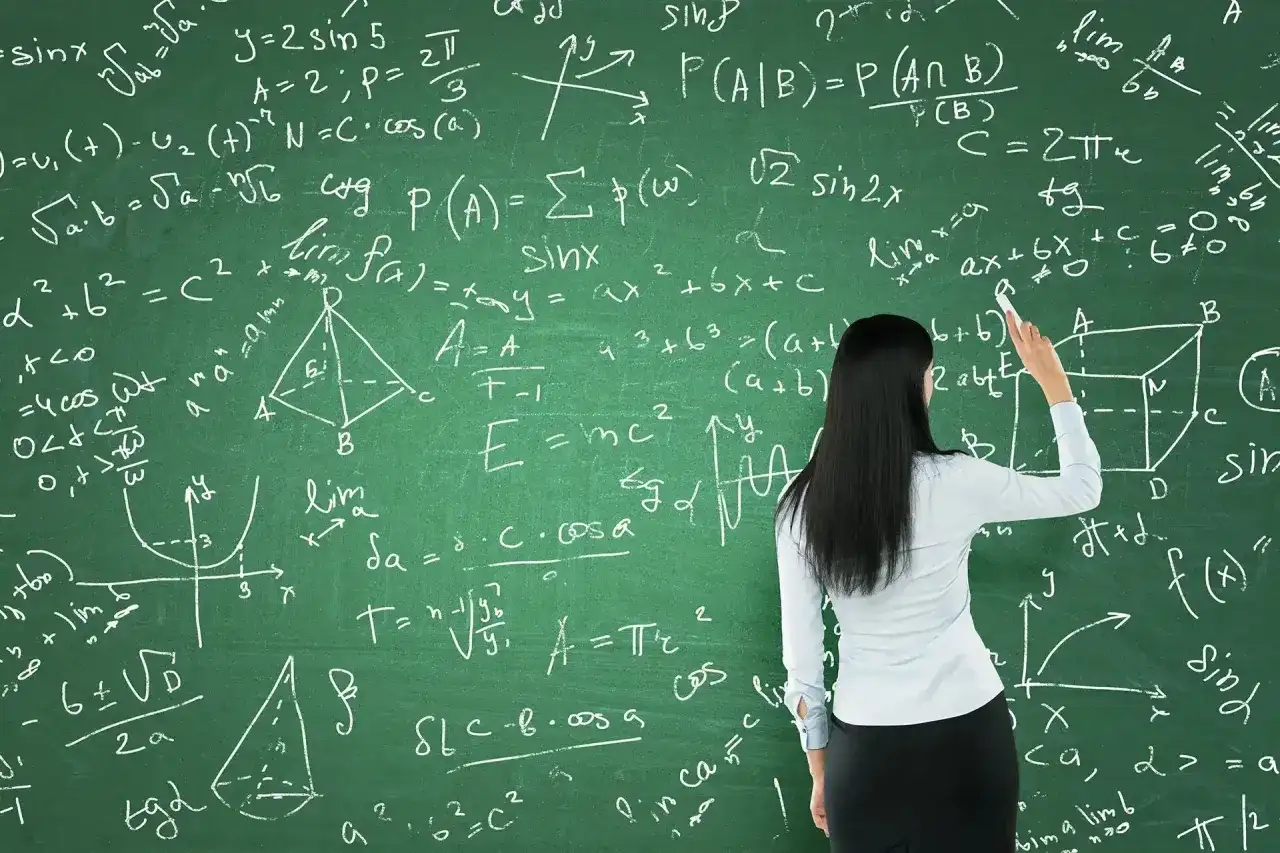 Nauczycielka pisze na tablicy wzory matematyczne, przygotowując się do tego, jak zdać maturę z matematyki.